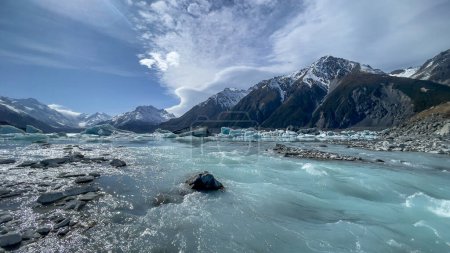 Téléchargez les photos : La rivière Tasman se précipite hors du lac alpin laissant derrière elle beaucoup d'icebergs à la surface du lac - en image libre de droit