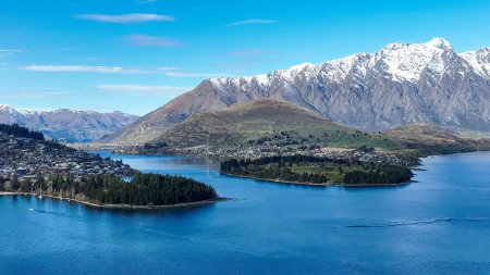 Photo for Drone panoramic view of the bays and inlets at Queenstown town at the southern end of Lake Wakatipu with a backdrop of the snow capped Remarkables Mountain range - Royalty Free Image