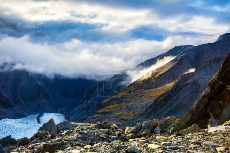 Photo for Sunlight breaking through the cloud warming this side of the valley with Franz Josef Glacier below - Royalty Free Image