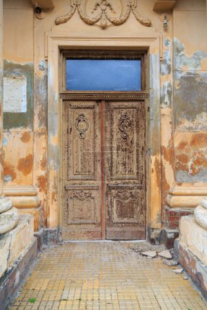 Photo for Ancient wooden carved door with stucco molding on the facade of the ancient historical building - Royalty Free Image