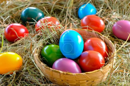 Téléchargez les photos : Easter painted eggs in a beautiful wicker basket for the Easter holiday - en image libre de droit