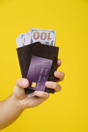 Téléchargez les photos : Une personne est représentée tenant une carte de crédit dans sa main, avec une vue claire des détails de la carte de crédit. - en image libre de droit