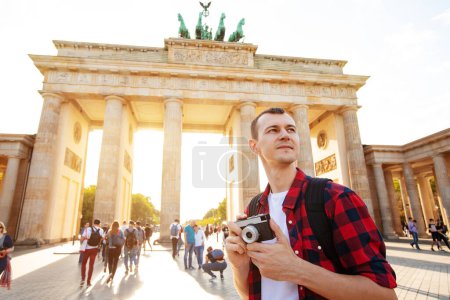 Téléchargez les photos : Voyage à Berlin, touriste avec caméra devant la porte de Brandebourg, Berlin, Allemagne - en image libre de droit