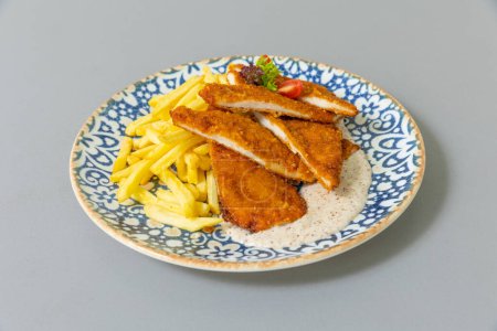 Photo for Tender pan fried chicken breasts served with french fries - Royalty Free Image