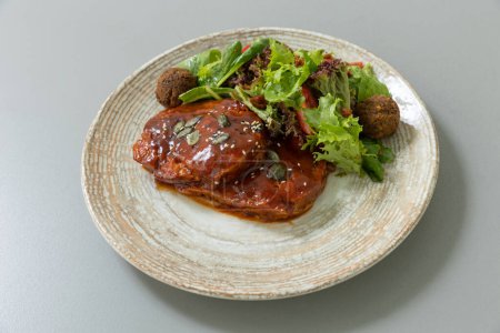 Téléchargez les photos : Viande avec sauce servie avec salade verte mélangée - en image libre de droit
