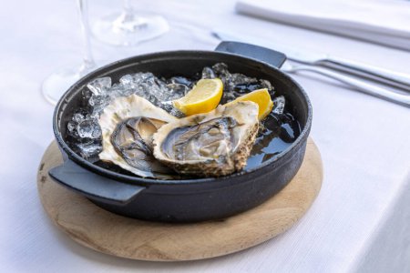Téléchargez les photos : Huîtres servies sur une table de restaurant avec du vin - en image libre de droit