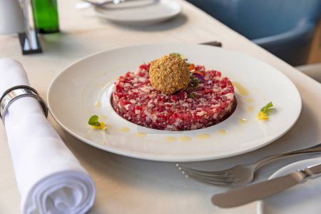 Téléchargez les photos : Boeuf tartare servi sur une assiette blanche dans le restaurant - en image libre de droit