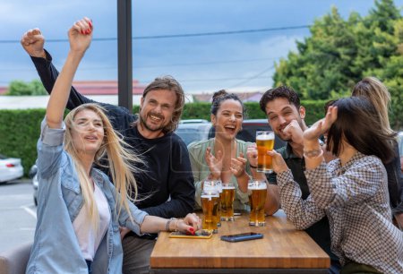 Foto de Amigos felices bebiendo cerveza en un bar - Imagen libre de derechos