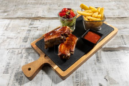 Foto de Ribs served on a plate with french fries and dip - Imagen libre de derechos