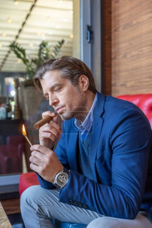 Photo for Man lighting cigar with a match - Royalty Free Image