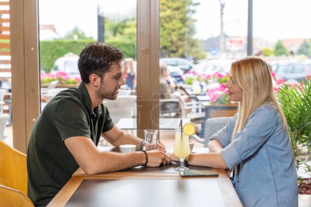 Photo for Happy romantic couple sitting in a cafe bar, talking - Royalty Free Image