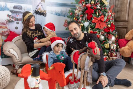 Téléchargez les photos : Happy family with kids playing with Christmas presents - en image libre de droit