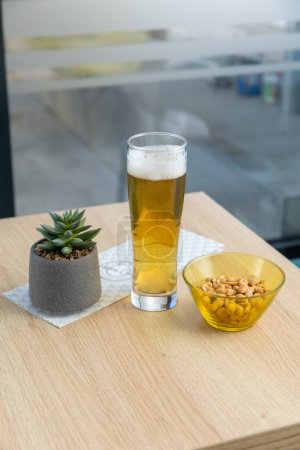 Foto de Cerveza y cacahuetes servidos en un bar - Imagen libre de derechos