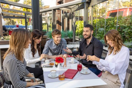 Photo for Friends talking in a outside cafe bar - Royalty Free Image