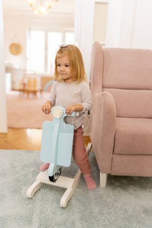Photo for Toddler baby playing on the rocking bike in the kindergarten - Royalty Free Image