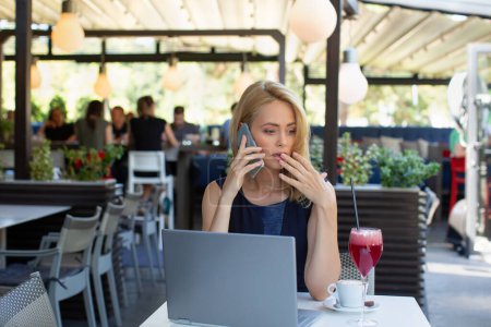 Foto de Empresaria conmocionada hablando en el teléfono inteligente en el restaurante, concepto de malas noticias - Imagen libre de derechos
