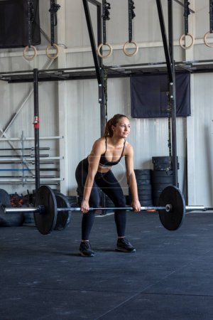Photo for Woman lifting weight in the gym - Royalty Free Image