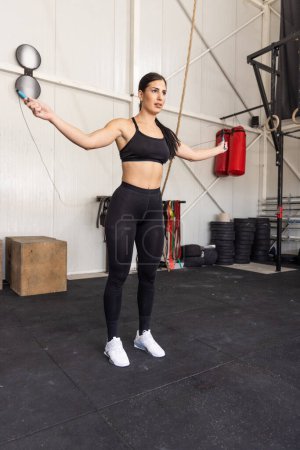 Téléchargez les photos : Femme de fitness sautant sur la corde à sauter dans la salle de gym - en image libre de droit