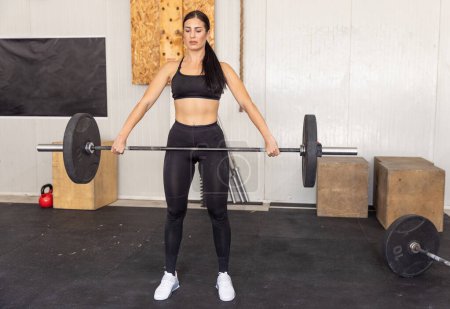 Téléchargez les photos : Fitness femme levant haltère dans la salle de gym - en image libre de droit