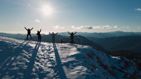 Foto de Éxito objetivo del equipo de cuatro montañistas que celebran la primera nevada en las montañas de la cumbre - Imagen libre de derechos