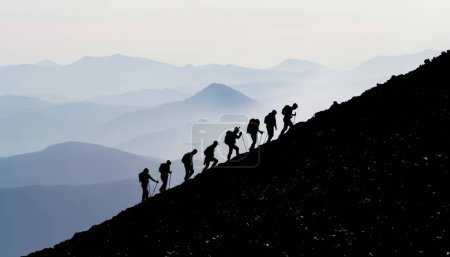 siluetas del equipo escalando las montañas de la cumbre