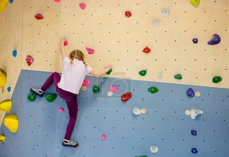 Photo for Girl child do bouldering known as free climbing exercise indoors leisure activity. - Royalty Free Image