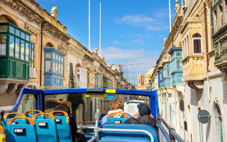 Foto de Conducir por Malta con hop on hop off autobús turístico. Hermoso casco antiguo de Malta con tradicionales balcones malteses de madera coloridos llamados La Gallarija. - Imagen libre de derechos