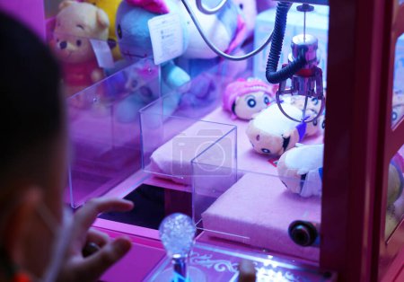 Foto de Niño borroso juego en primer plano máquina expendedora de garras - Imagen libre de derechos