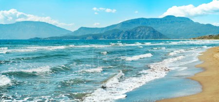 Téléchargez les photos : Seascape with waves at sunny day at beautiful sandy empty beach. Beautiful mountain range on background. Iztuzu in Turkey - en image libre de droit
