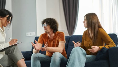 Unglückliches Paar streitet und äußert seine Beziehungsprobleme während einer Therapiesitzung mit Psychologen. Ehetherapie. Lösung von Beziehungsproblemen