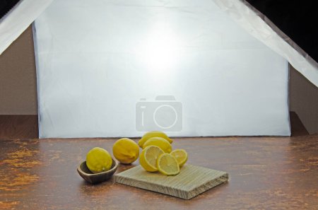 Home photo studio set up of fresh sliced lemons on a wooden board with studio lighting