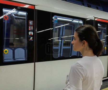 Téléchargez les photos : Femme attendant que les portes du métro s'ouvrent et s'arrêtent pour pouvoir entrer et se rendre à destination avec une attention sélective - en image libre de droit