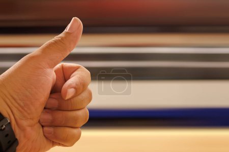 Téléchargez les photos : Main avec doigt levé donnant un OK tandis qu'un train de vitesse passe avec l'espace de copie et la mise au point sélective. - en image libre de droit