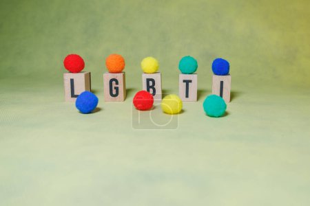 Téléchargez les photos : Mot LGBTI avec des lettres en bois décorées avec différentes boules de couleur avec fond jaune et espace de copie. - en image libre de droit