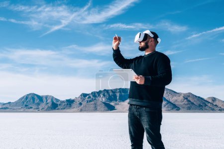 Foto de Larga duración del hombre toca con espacio de simulación de lápiz digital usando auriculares para crear una dimensión de realidad virtual. Hombre que utiliza tableta para controlar el aumento del entorno VR que se encuentra al aire libre. - Imagen libre de derechos