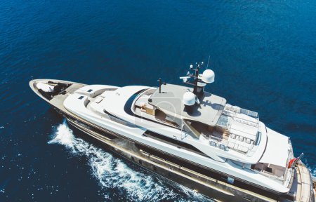 Téléchargez les photos : Vue aérienne du yacht de luxe va à la mer avec une belle couleur bleue de l'eau. Mode de vie récréatif riche. Oiseaux vue d'un navire flottant coûteux voyageant en Europe en été - en image libre de droit