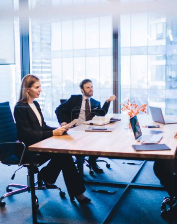 Téléchargez les photos : Les gens d'affaires d'entreprise coopérant sur des idées pour la stratégie financière de l'entreprise lors d'une réunion de remue-méninges à l'intérieur du bureau, quatre employés communiquant et discutant des idées assis à la table - en image libre de droit