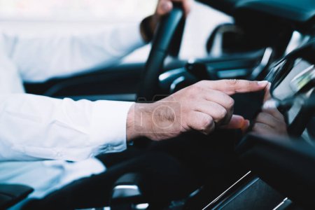 Iot-System mit während der Kfz-Lenkung in zeitgenössischen Auto, Mann Fahrer Überprüfung der Position Richtung auf Automobil-Technologie berühren Armaturenbrett-Display für die Verfolgung gps auf Head-up-Cockpit