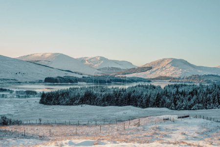 Loch Tulla and snow-covered mountains in the Scottish highlands, from a viewpoint on the A82
