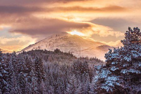 Der schneebedeckte Gipfel des Stob a 'Choire Mheadhoin, eines Munro-Berges in den schottischen Highlands, bei Sonnenuntergang. Vom Laggan Dam aus gesehen