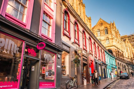 Photo for Edinburgh, Scotland - January 22nd, 2024: colorful pink storefront and other painted buildings along West Bow and Victoria Street in Edinburgh Old Town - Royalty Free Image