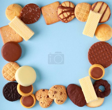 Téléchargez les photos : Assorted cookies square shape with copy space on blue background - en image libre de droit