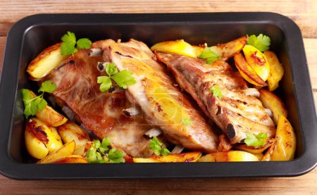 Photo for Roast pork ribs with potatoes in baking tray - Royalty Free Image