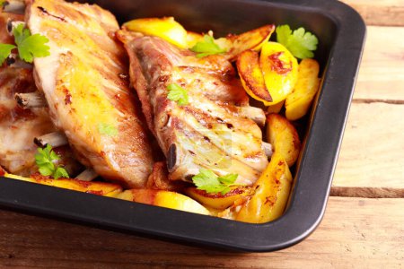 Foto de Roast pork ribs with potatoes in baking tray - Imagen libre de derechos