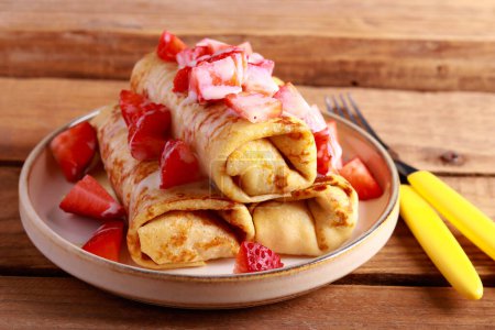 Photo for Crepe rolls with filling, condensed milk and strawberry topping - Royalty Free Image