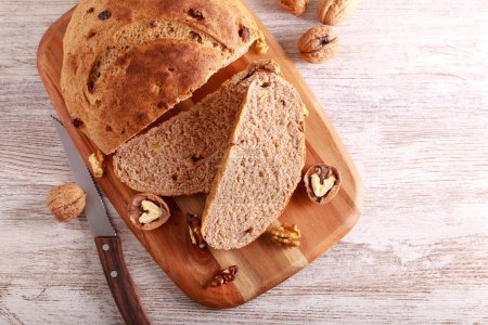 Téléchargez les photos : Homemade walnut whole wheat bread, sliced on wooden board - en image libre de droit