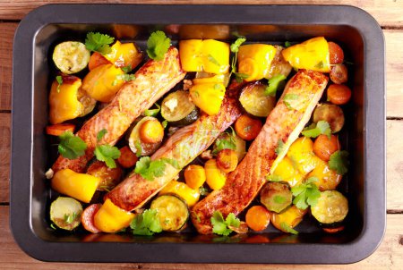 Téléchargez les photos : Roast salmon with vegetables on baking tray - en image libre de droit