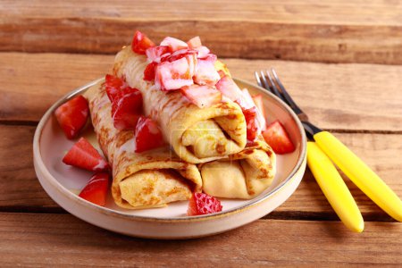 Téléchargez les photos : Crepe rolls with filling, condensed milk and strawberry topping - en image libre de droit