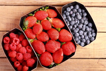 Photo for Fresh mixed berries - blueberry, strawberry and raspberry in boxes - Royalty Free Image