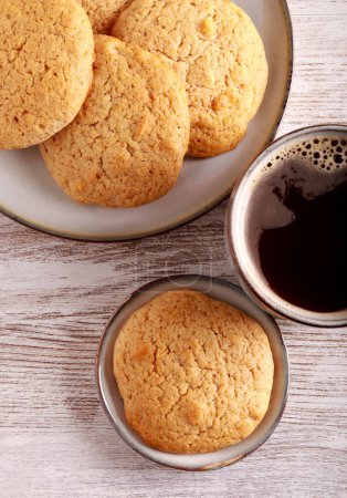 Téléchargez les photos : Biscuits maison aux noix et noix de coco avec tasse de café - en image libre de droit